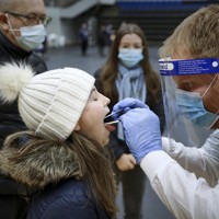 新型コロナウイルスに感染していないか検査を受ける女の子＝デンマークの北ユトランドで7日、AP