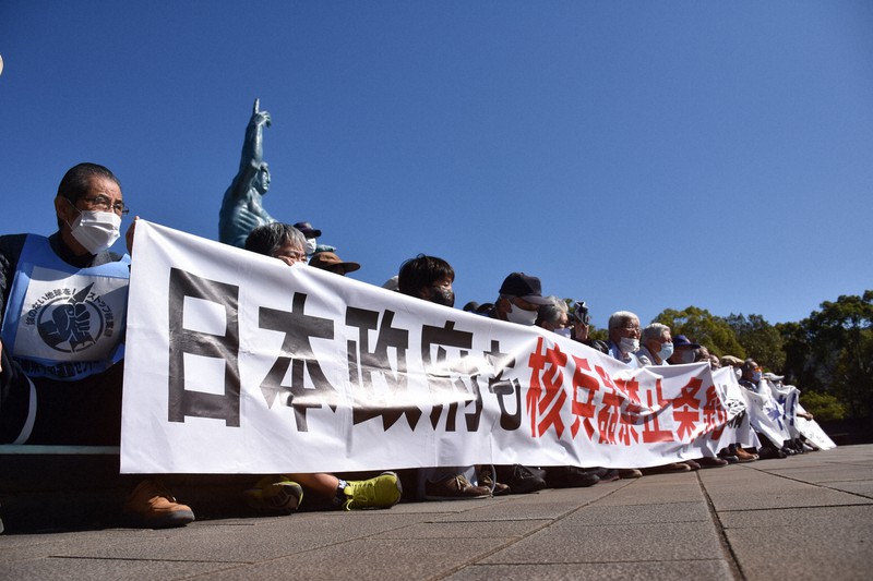 平和祈念像前に座り込む被爆者ら。バイデン氏への期待と注文の声が相次いだ=長崎市の平和公園で2020年11月9日午後0時18分、今野悠貴撮影