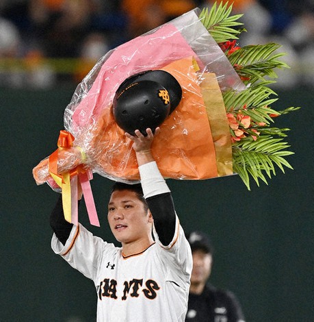 通算2000安打を達成し、贈られた花束を掲げる巨人の坂本=東京ドームで8日、宮間俊樹撮影