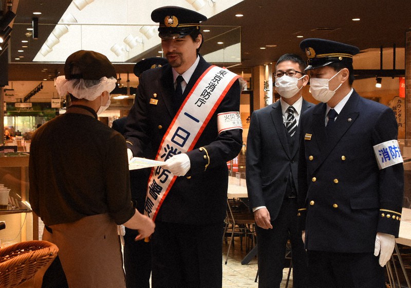 チラシを配って火災への注意を呼びかける城田優さん=東京都町田市で2020年11月6日午前9時44分、鈴木拓也撮影