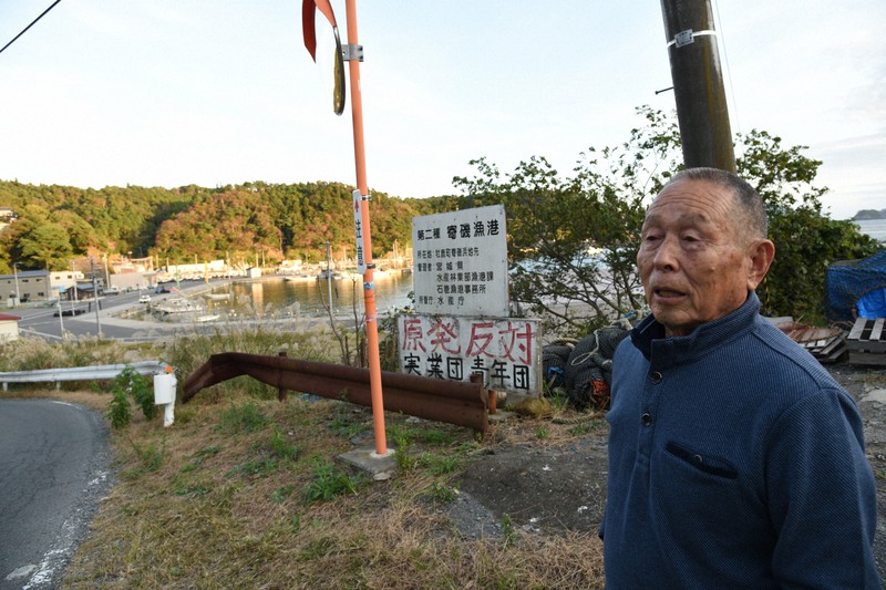 再稼働の危険性を訴える元漁師の渡辺幸敏さん。地区には地元の若い世代が組織する青年団などが数十年前に設置した「原発反対」の看板がいくつもある=宮城県石巻市寄磯浜で2020年10月21日午後4時24分、百武信幸撮影