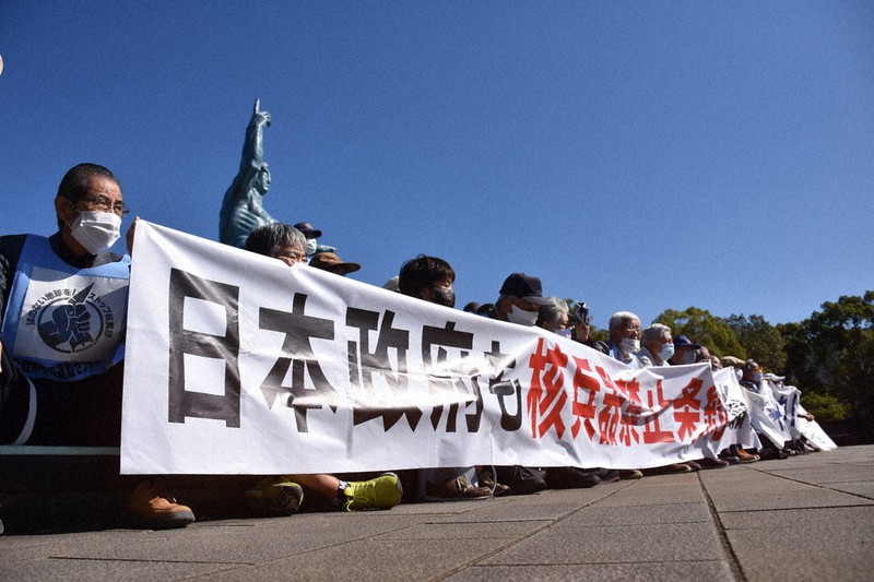 平和祈念像前に座り込む被爆者ら。バイデン氏への期待と注文の声が相次いだ=長崎市の平和公園で2020年11月9日午後0時18分、今野悠貴撮影