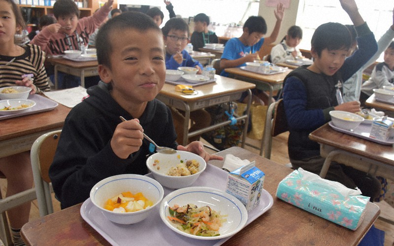 給食でガパオライスをほおばる児童たち