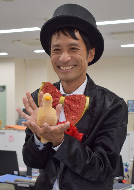 手からハトのぬいぐるみを出すハッピー浅田さん=兵庫県尼崎市若王寺2の子どもの育ち支援センター「いくしあ」で2020年10月6日午後0時22分、稲田佳代撮影