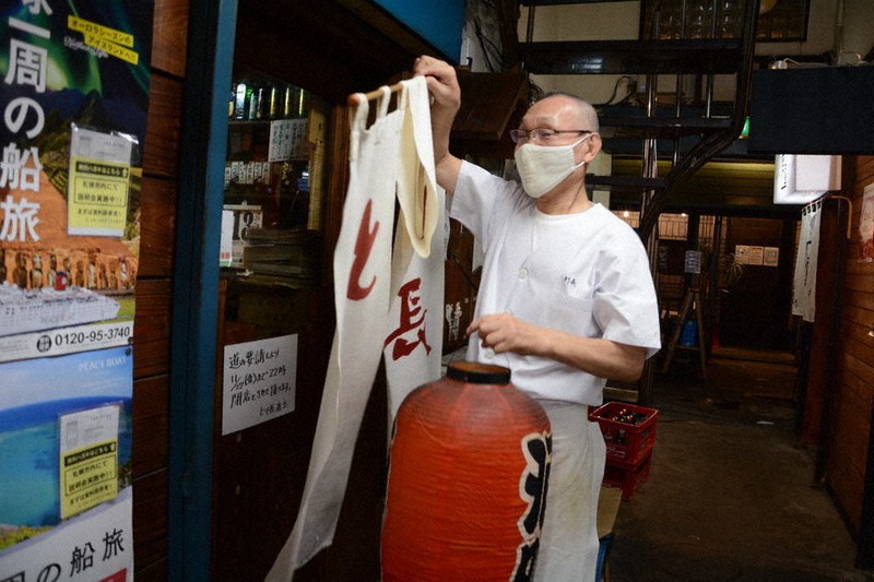 のれんを外し、店じまいする焼き鳥店「とり長」の長尾良さん=札幌市中央区で2020年11月13日午後9時53分、岸川弘明撮影
