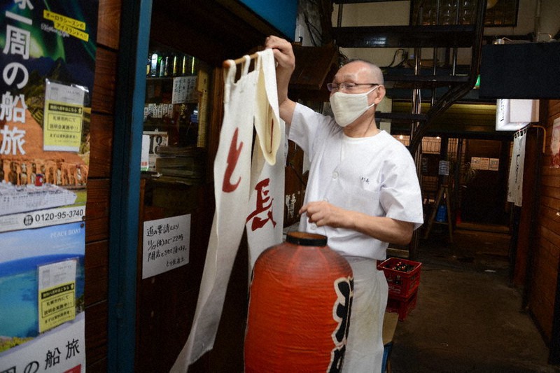 のれんを外し、店じまいする焼き鳥店「とり長」の長尾良さん＝札幌市中央区で２０２０年１１月１３日午後９時５３分、岸川弘明撮影