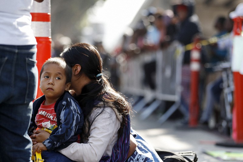 米国への難民認定の手続きで順番を待つ親子=メキシコ北西部ティフアナで2019年7月16日、AP