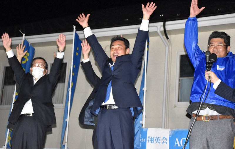 初当選を決め、支援者らと万歳をする上村英司氏(中央)=山梨県北杜市で2020年11月15日午後11時44分、金子昇太撮影