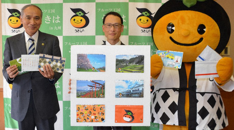 うきは市の名所などがデザインされたマスクケースを手にする(左から)高木市長、母里社長、うきぴー