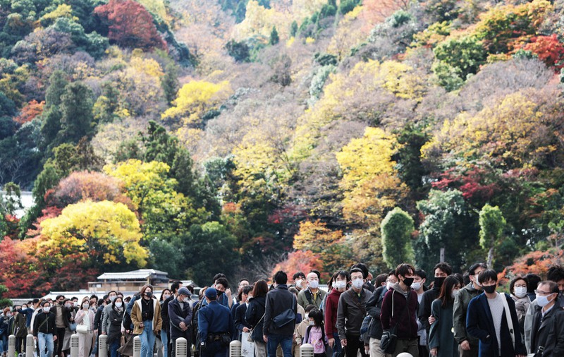 紅葉が見ごろを迎えた京都の嵐山を訪れ、渡月橋で列を作る観光客=京都市右京区で2020年11月21日午前11時21分、小出洋平撮影