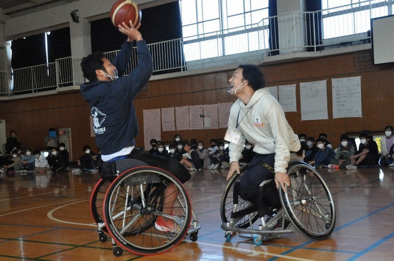 車いすバスケを実演する堀江航選手(左)と三元大輔選手=横浜市港南区の日野南小で2020年11月13日、五十嵐朋子撮影