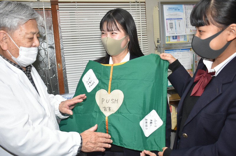 診療所の医師(左)にAEDシートの説明をする熊野高校の生徒ら=上富田町朝来で2020年11月24日午後4時35分、竹内之浩撮影