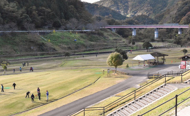 流水型の益田川ダムの「貯水池」。平常時は水がたまっておらず、整備されたグラウンドゴルフ場は地元の人らでにぎわう。斜面や橋の橋脚に満水時の水位が青色で表示されている=島根県益田市で2020年11月9日午後2時33分、平川昌範撮影