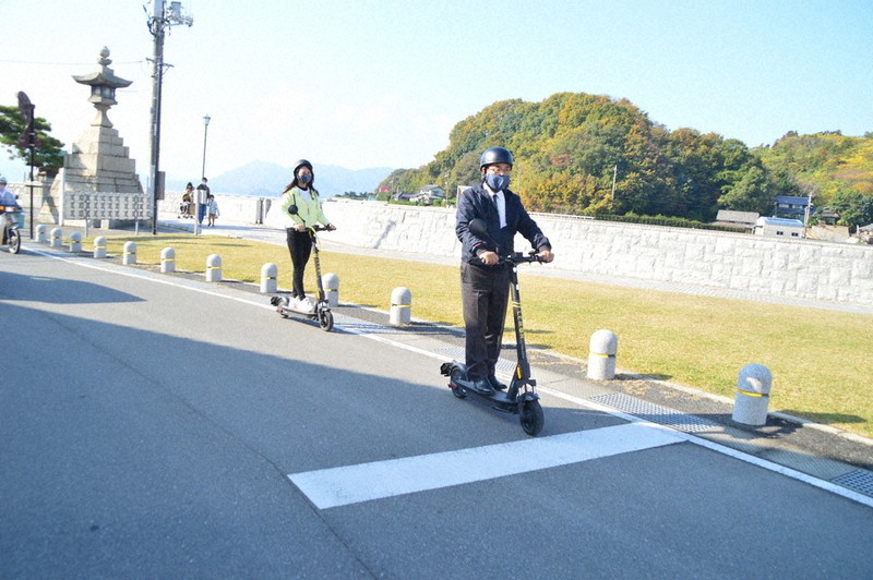 電動キックボードで公道を走る平谷祐宏市長(手前)ら=広島県尾道市瀬戸田町瀬戸田で2020年11月27日午前10時26分、渕脇直樹撮影
