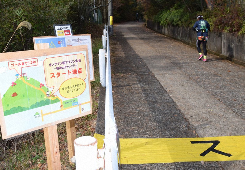 オンラインマラソンのスタート地点。試走するランナーの姿も=奈良県王寺町で、熊谷仁志撮影