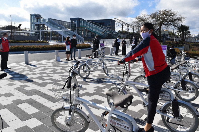 JR竜田駅前にオープンした太陽光発電による電動アシスト付き自転車の「サイクルポート」。奥は完成した駅の東西自由通路=福島県楢葉町井出で2020年11月30日午後0時5分、柿沼秀行撮影