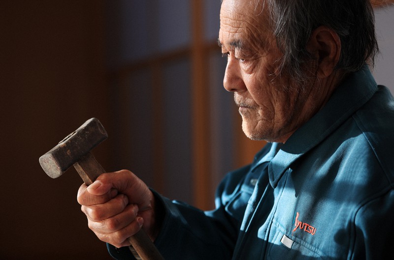 「働くのが生きがいだったんだけどな」。震災前から相棒だった金づちを見つめる楠原盛司さん=宮城県南三陸町で2020年11月12日、梅村直承撮影