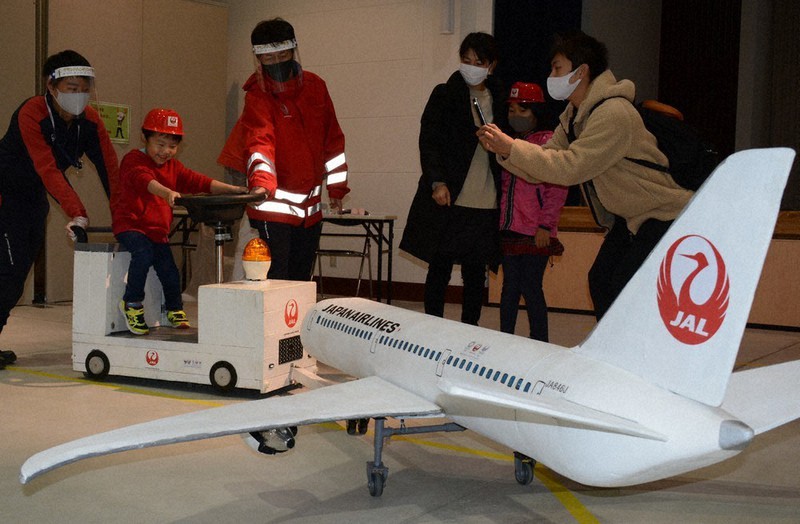特殊車両の台車のハンドルを操作し、航空機の模型を押す子ども=千葉県芝山町で2020年11月29日、中村宰和撮影