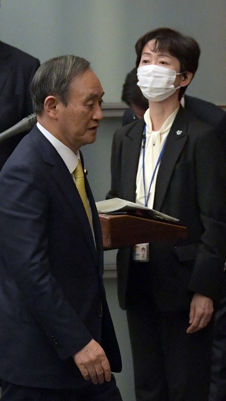 記者会見を終えて退出する菅義偉首相。右は山田真貴子内閣広報官=首相官邸で2020年12月4日午後6時50分、竹内幹撮影