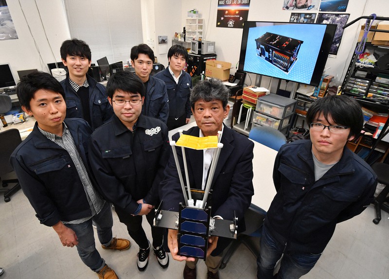 超小型人工衛星「ひろがり」の模型を手に持つ大阪府立大の小木曽望教授(右から2人目)と開発に携わった学生たち=堺市で2020年10月23日、木葉健二撮影