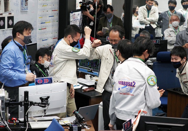 はやぶさ2のカプセル分離を確認し、運用メンバーと喜ぶ津田雄一プロジェクトマネジャー(中央右)=相模原市中央区のJAXA相模原キャンパスで2020年12月5日午後2時35分、JAXA提供