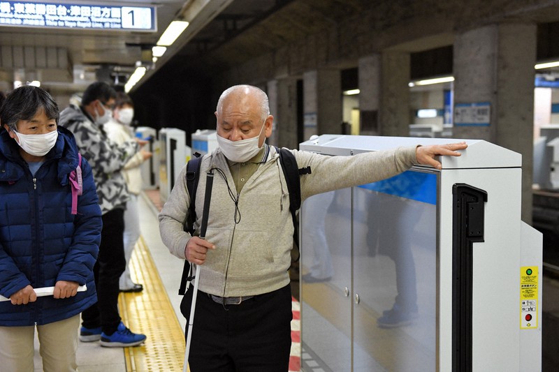 11月29日に視覚障害者の男性が転落し電車にはねられて死亡した東京メトロ東陽町駅で、白杖を手にホームドアを視察する全日本視覚障害者協議会の山城完治さん(中央)=東京都江東区で2020年12月6日午後5時15分、北山夏帆撮影