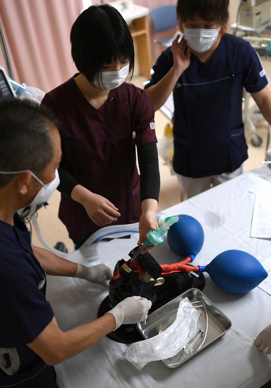 重症患者の増加を受け、医師(左手前)から人工呼吸器の挿管の指導を受ける看護師たち=大阪市住吉区の阪和第二病院で2020年11月26日、久保玲撮影
