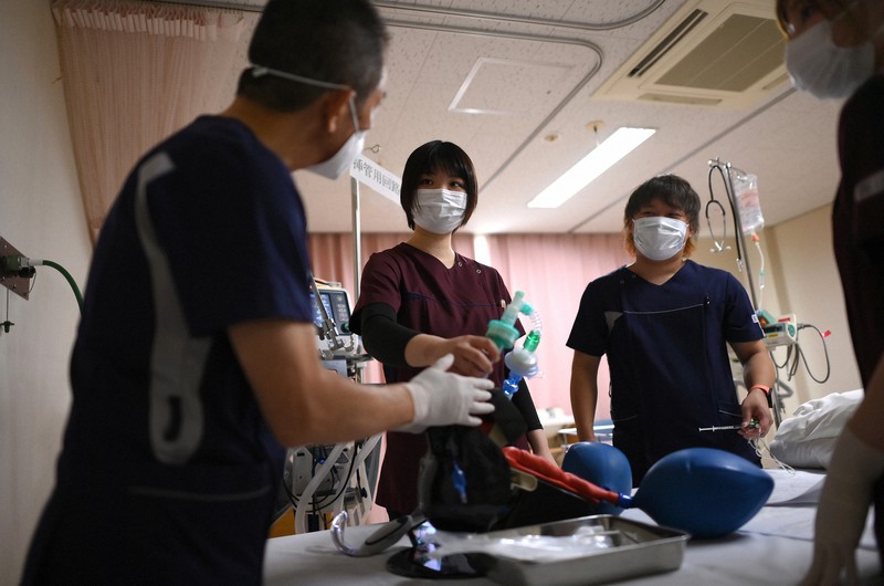 重症患者の増加を受け、医師(左)から人工呼吸器の挿管の指導を受ける看護師たち=大阪市住吉区の阪和第二病院で2020年11月26日、久保玲撮影