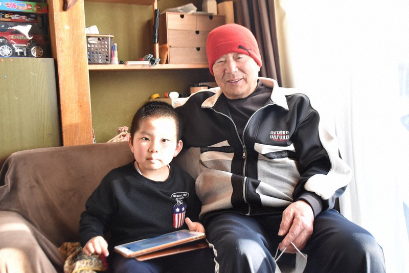 孫の湊大ちゃん(左)を前に笑顔を見せる横山武志さん=宮城県南三陸町で2020年11月14日午後3時6分、滝沢一誠撮影