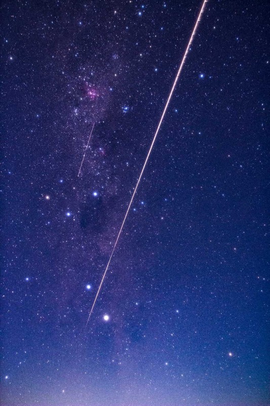 カプセルが大気圏に突入し、オーストラリア南部の上空で観測された光跡。南十字星をかすめて飛んで行った=2020年12月6日未明、JAXA提供