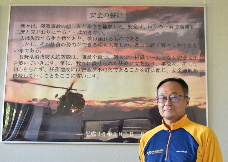 「安全の誓い」の前で気を引き締める手塚勇樹さん=長野県松本市空港東の県消防防災航空センターで2020年10月21日、坂根真理撮影
