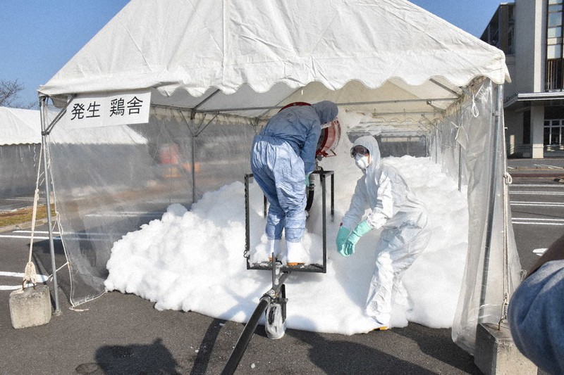 鳥インフルエンザ発生に備えた防疫演習で、鶏舎を想定したテントの中で泡殺鳥機を稼働させる参加者ら=徳島県石井町石井の県立農林水産総合技術支援センターで2020年12月7日午後1時50分、岩本桜撮影