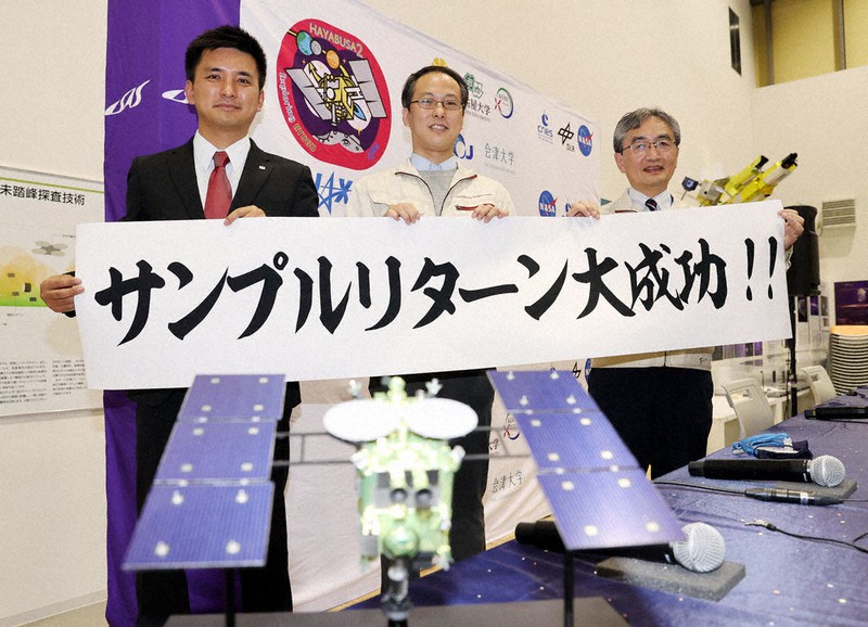 記者会見後、横断幕を手に笑顔を見せるJAXAの(左から)臼井寛裕教授、津田雄一プロジェクトマネジャー、吉川真ミッションマネジャー=相模原市中央区で8日午後2時22分、幾島健太郎撮影
