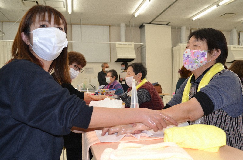 ハンドマッサージを受ける災害公営住宅の女性=岩手県釜石市大町の青葉ビルで