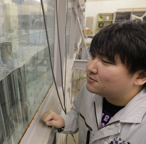 防潮林の模型を使って津波の威力を減らす実験に取り組む堀合紳弥さん=青森県八戸市で11月、和田大典撮影
