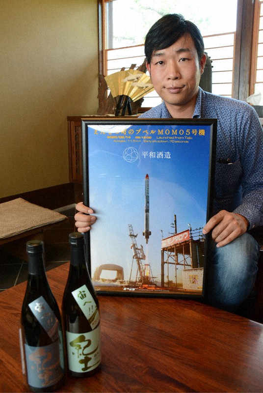 ロケットの燃料に使われた日本酒「紀土」と平和酒造の山本典正社長=和歌山県海南市で10月11日