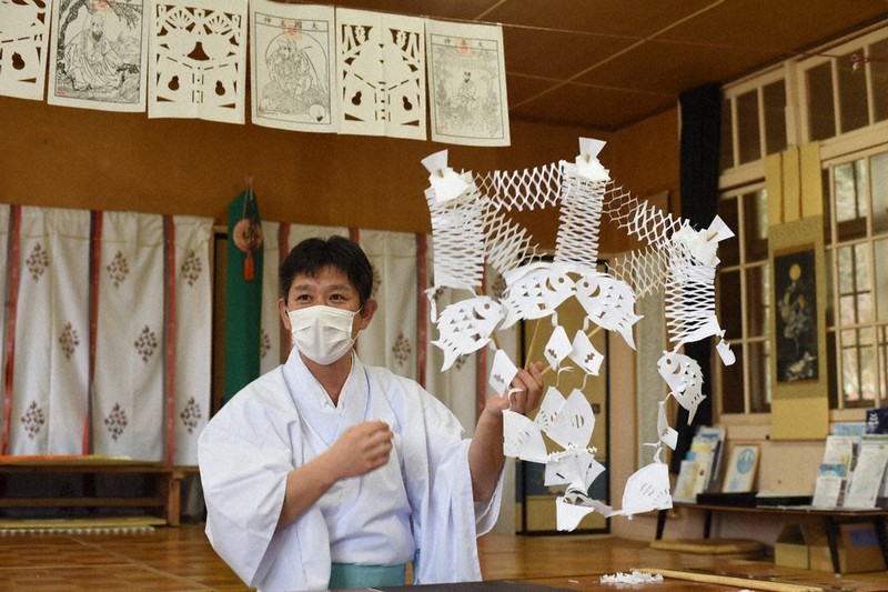 作り終えた「鯛飾り」を手にする上山八幡宮の宮司、工藤庄悦さん。左奥は供物に見立てた餅や御神酒をかたどったお飾り=宮城県南三陸町で、2020年12月3日、神内亜実撮影