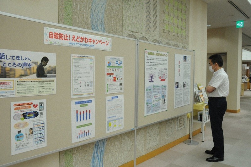 家族を自殺で失った遺族の手記などをパネル展示した東京都江戸川区の取り組み。相談先のパンフレットや関連書籍もそろえた=江戸川区立中央図書館で9月、谷本仁美撮影