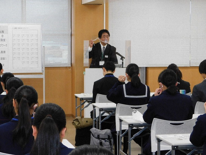 県立芸術文化観光専門職大学の学校推薦型選抜で、受験生にマウスシールドの使い方を説明する試験官=豊岡市幸町の県豊岡総合庁舎で2020年12月12日午前8時37分、村瀬達男撮影