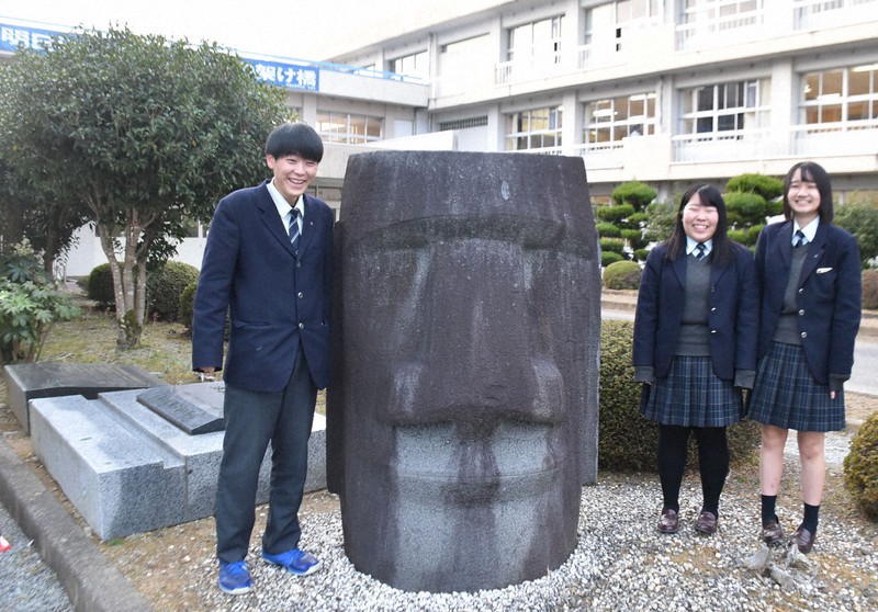 志津川高校に置かれた、頭部だけのモアイ像の横に立つ(左から)佐藤信太郎さん、管野莉緒さん、伊東美咲さん=宮城県南三陸町で2020年12月3日午後3時45分、滝沢一誠撮影