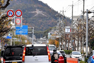 西大路通を北へ駆ける選手たちに見えてくる左大文字＝京都市北区の大将軍付近で2019年12月7日、川平愛撮影