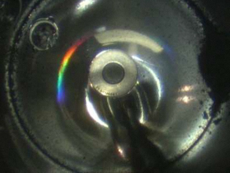 小惑星探査機「はやぶさ2」のカプセル内で確認された黒い砂粒状の粒子(右側)=JAXA提供