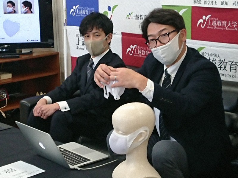 マスクの構造を説明するオンヨネの担当者、左は池川茂樹上越教育大准教授=新潟県上越市で2020年12月10日、石塚誠撮影