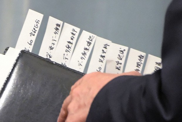 記者会見に臨む菅義偉官房長官が持つ多くの資料には、安倍晋三首相主催の「桜を見る会」を巡るさまざまな項目が書かれた付箋がつけられていた=首相官邸で2019年11月29日、川田雅浩撮影