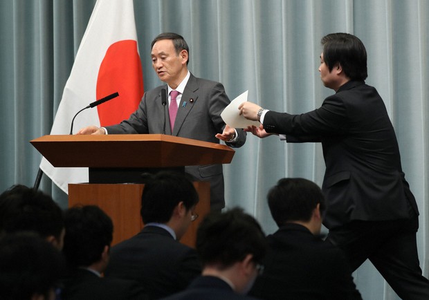 記者会見で「桜を見る会」をめぐる質問で事務方からのメモを手にする菅義偉官房長官=首相官邸で2019年12月5日午前11時35分、佐々木順一撮影