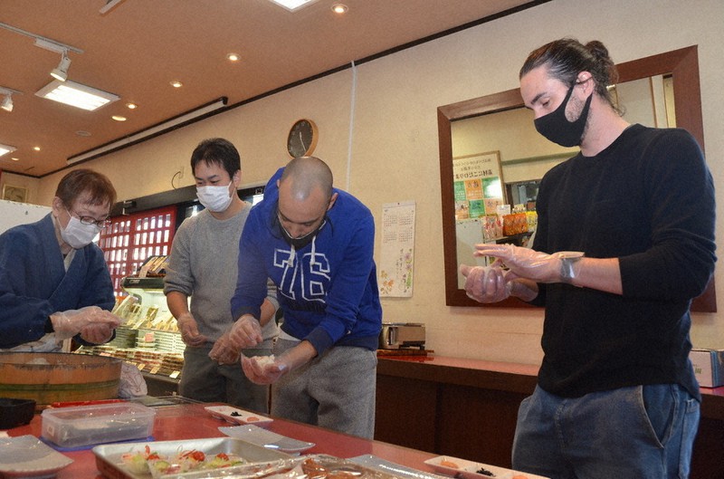 高橋千代子さん(左)の指導でおむすびを握る参加者ら=茨城県古河市中央町3で2020年12月21日、安味伸一撮影
