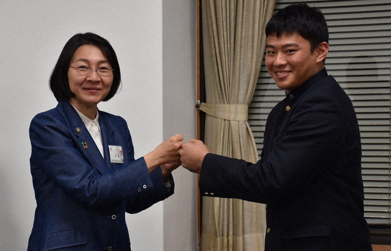 伊東香織市長(左)とグータッチする玉島の岡本拓也主将=岡山県倉敷市役所で、岩本一希撮影