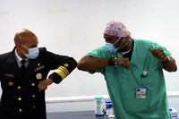 Surgeon General of the U.S. Jerome Adams, left, elbow-bumps Emergency Room technician Demetrius Mcalister after Mcalister got the Pfizer COVID-19 vaccination at Saint Anthony Hospital in Chicago, on Dec. 22, 2020. (Youngrae Kim/Chicago Tribune via AP, Pool)
