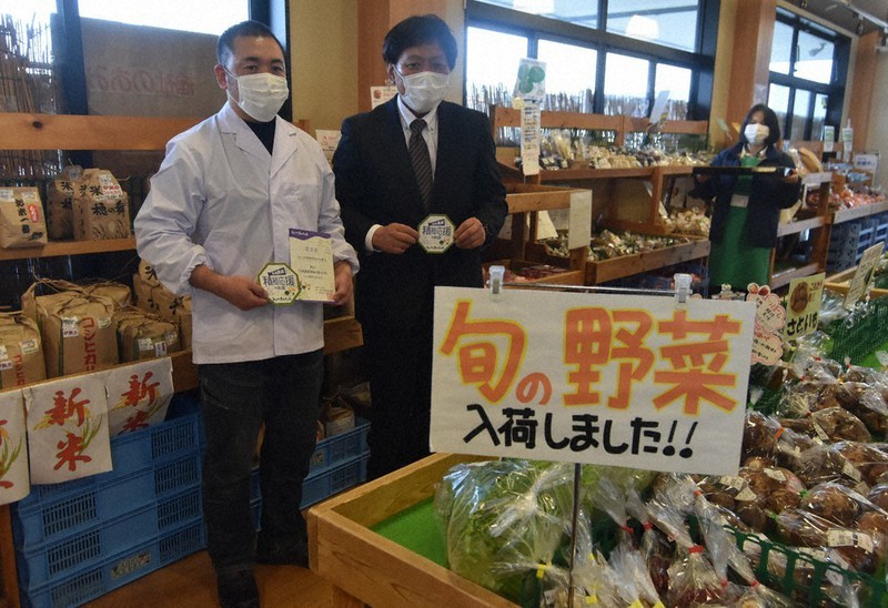 杉本一徳・名張市産業部長から「名張農業積極応援のお店」の認定証などを受け取る安藤弘和さん(左)=三重県名張市希央台2で、衛藤達生撮影