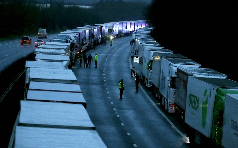 英南部ドーバー付近の高速道路で車列が動き出すのを待つ多数のトラック=23日、AP